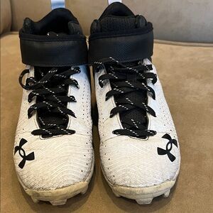 Under Armour Kids' Black and White baseball/football cleats.